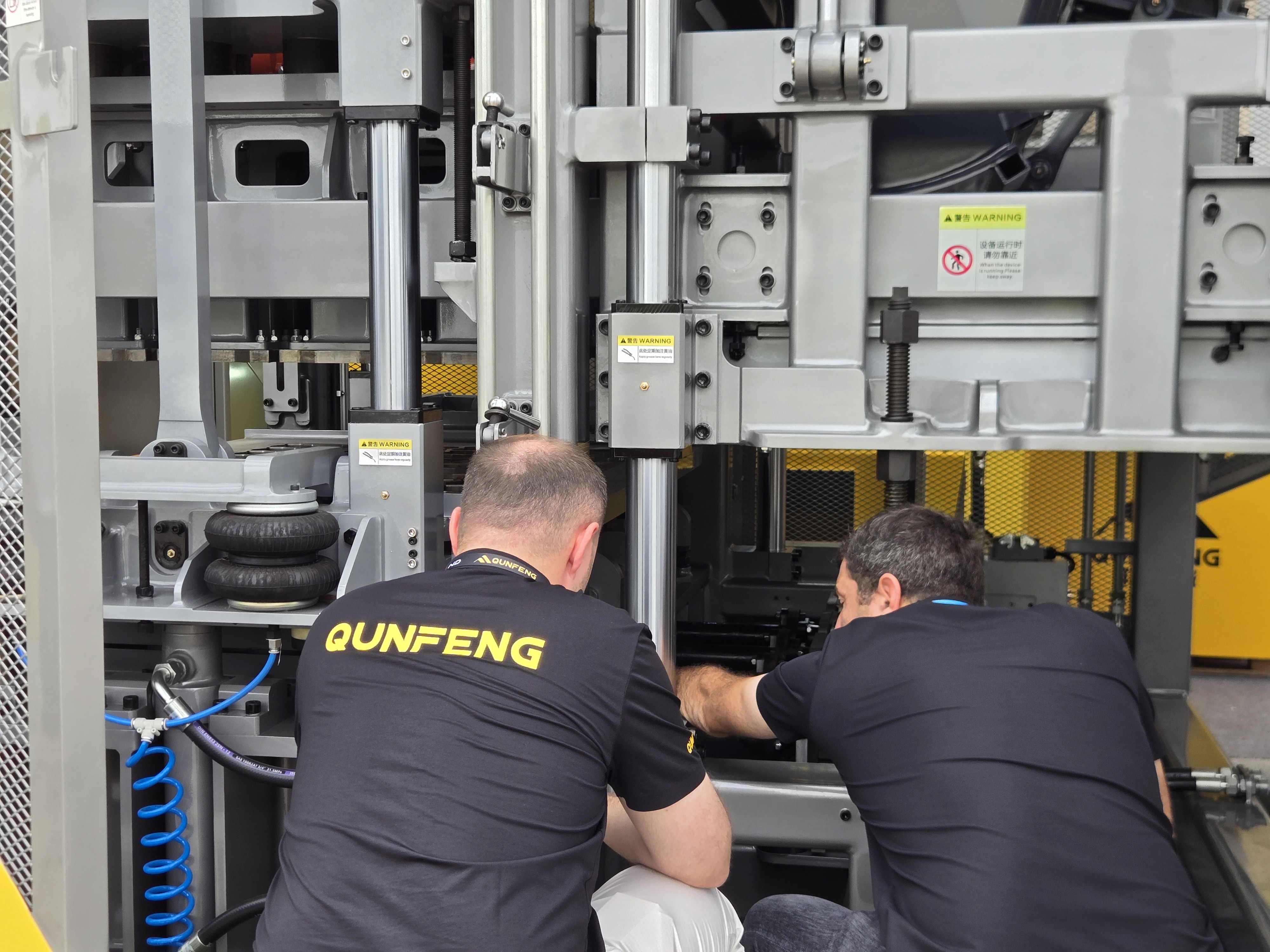 A Russian client carefully examines the details of Qunfeng Machinery equipment. Pelanggan Rusia meneliti butiran peralatan Jentera Qunfeng dengan teliti.
